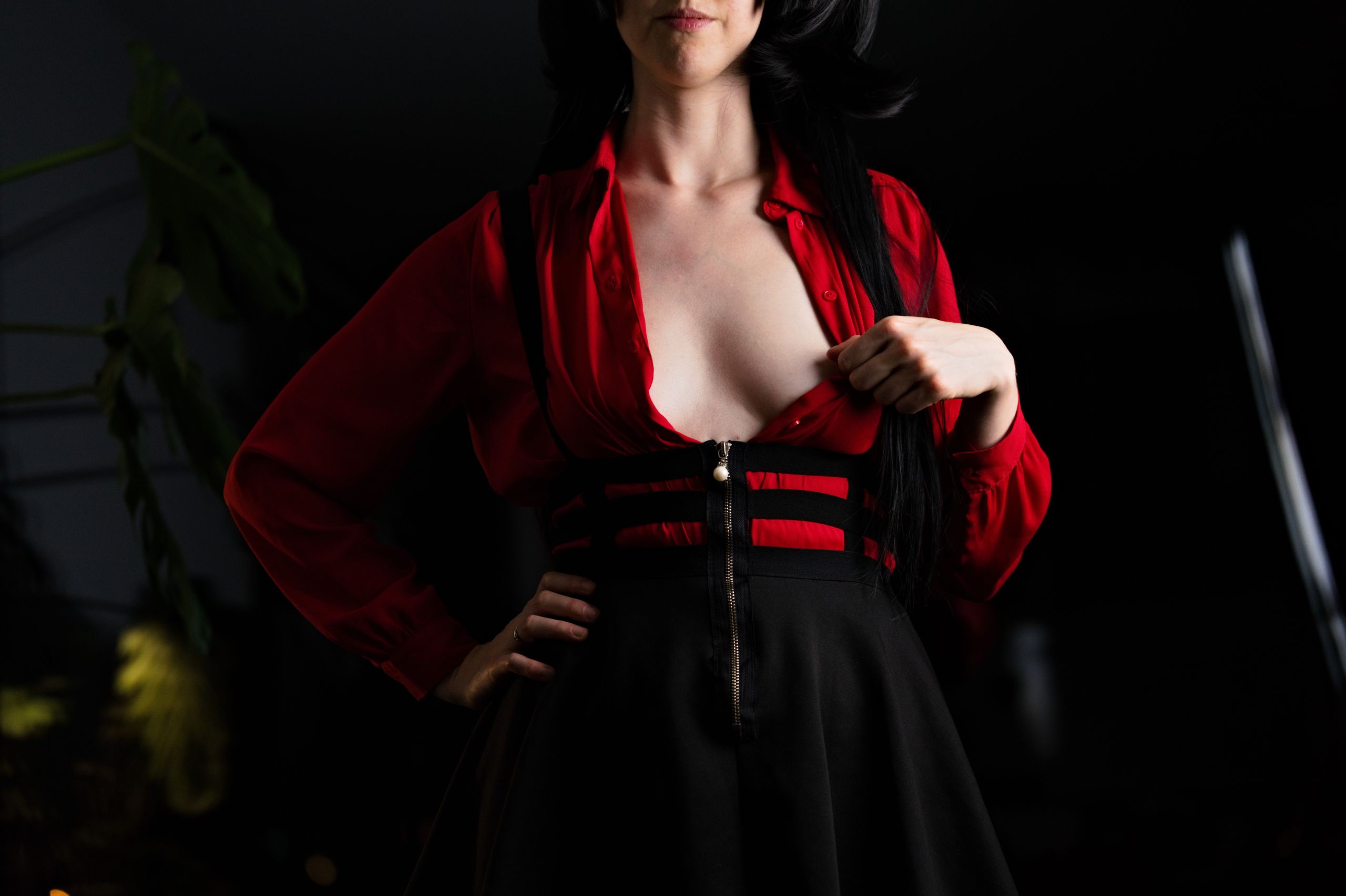 Shizuka Kawa cosplaying as Fuyuko Mayuzumi from Idolmaster wearing red shirt and black skirt with suspenders. Looking into the camera with open shirt, showing inner sideboob.
